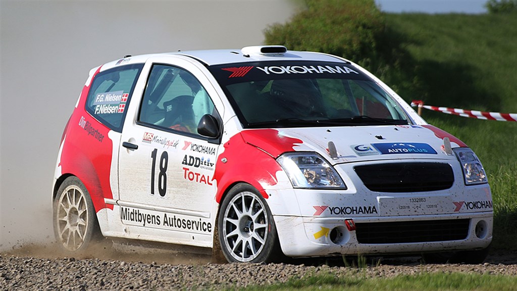 Frank Nielsen og Frits Grove Nielsen runder et at de udfordrende sving på et at grus stykkerne i Anderup El Rally 2018
(Foto: RallyFoto.dk – Alex Rasmussen)